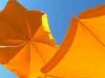 orange patio umbrellas and blue sky