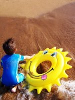 boy back with yellow tube at beach