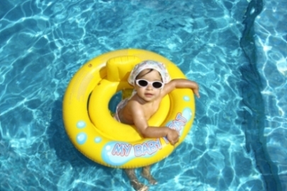 Baby in yellow tube in pool w sunglasses