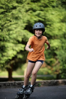 young girl roller blading in orange