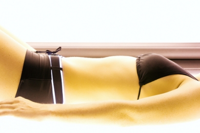 WOMAN TANNING IN SOLARIUM