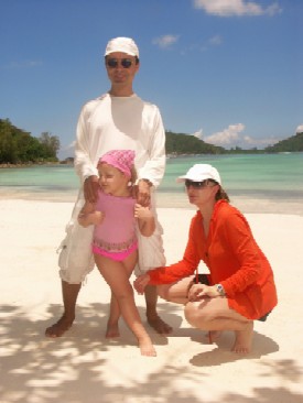 sun protective clothing man woman and little girl at the beach