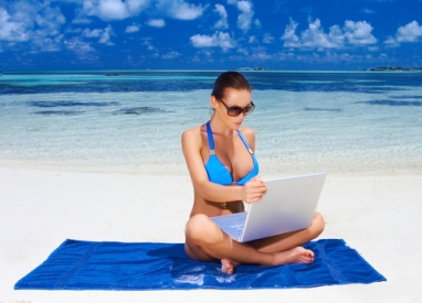 Woman w laptop sunglasses at beach