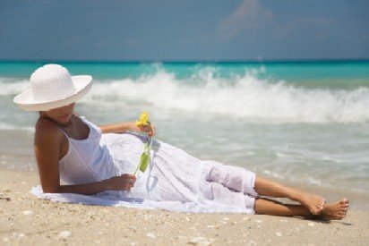sun protection clothing lady with white hat and dress laying on the beach