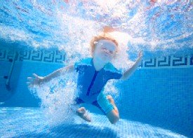 boy swimming under water in pool
